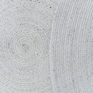 Close-up of a textured gray fabric on the Carousel Round Outdoor Rug in Creme
