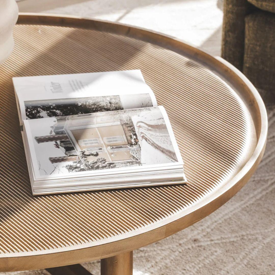 Open book on a round wooden table with a blurred background