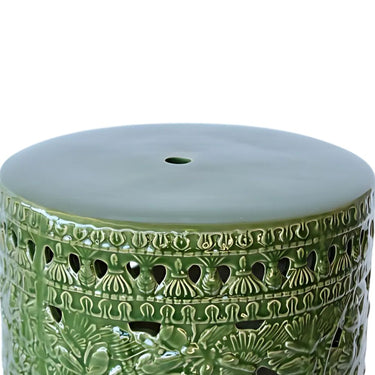 Elegant leaf detailing on ceramic stool, dark green side table