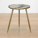 living room side table with a scalloped white and gray marble effect top and tripod gold metal legs.