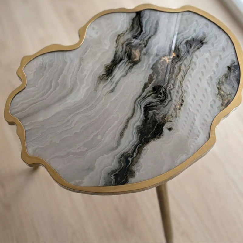 A scalloped agate-pattern side table with a gold metal frame and glass top.