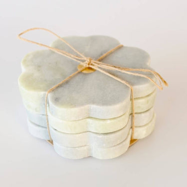 Set of four 11cm grey raw stone coasters with a scalloped flower edge and central brass inlay