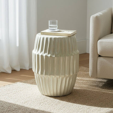 Pearla sculptural side table styled beside a occasional chair on a rug