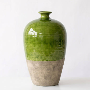 A ceramic vase with a glossy green upper body and a textured, matte light brown lower base, photographed against a plain white background.