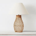 Modern coastal rattan lamp styled on a minimalist console highlighting its natural organic texture and bell-shaped base.