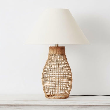 Modern coastal rattan lamp styled on a minimalist console highlighting its natural organic texture and bell-shaped base.