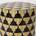Detailed view of the iridescent mother of pearl inlay and bold repeating triangle pattern on a cylindrical drum table.