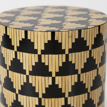 Detailed view of the iridescent mother of pearl inlay and bold repeating triangle pattern on a cylindrical drum table.