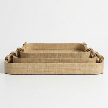 Three nested rectangular woven trays in a natural tan color, featuring rolled bamboo handles on the sides.