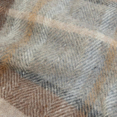 Close-up of a woven fabric with a plaid tartan weave in wool rich grey taupe cream and amber brown tones.