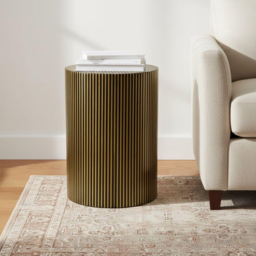 The Striped Accent Table styled beside an armchair as a natural material side table in an organic modern living room.