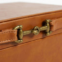 Close-up of a brown leather with a brass-toned buckle clasp and fine stitching on the tan decorative box.