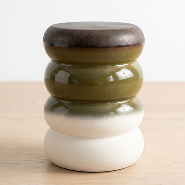 A ceramic decorative stool with a stacked, rounded design. The top section features a dark brown glazed finish, followed by olive green, a white-to-light-gray gradient section, and a solid matte off-white base.