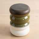terra stool three-tiered ceramic stool with a dark brown top, olive green middle, and white bottom.