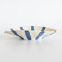 Organic shape and stucco-like texture on a hand-painted blue and cream ceramic serving dish.