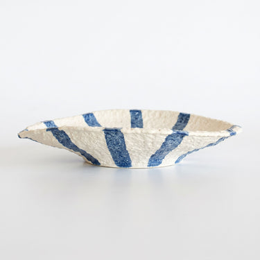 Organic shape and stucco-like texture on a hand-painted blue and cream ceramic serving dish.
