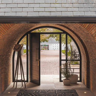 Thunderroot Rug styled in a spacious entryway as a bold outdoor rug accent