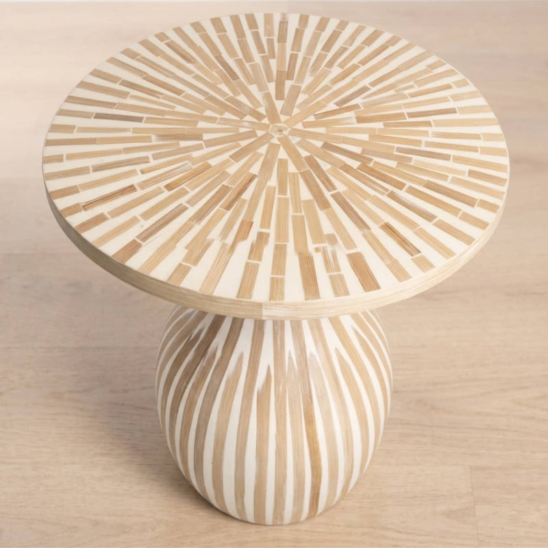 A round side table with a sunburst inlay pattern on the top and a bulbous pedestal base, shown on a light wood floor.