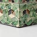 Capiz shell storage box edge with green and brown mosaic pattern.