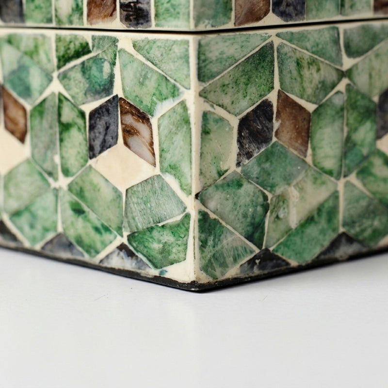 Capiz shell storage box edge with green and brown mosaic pattern.