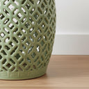 Detailed view of the intricate geometric lattice cut-outs on the vilasa green ceramic stool showing light-filtering craftsmanship.