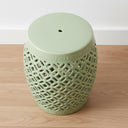 Top-down view of a pale green ceramic accent table with a smooth polished surface and open lattice edges.