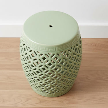 Top-down view of a pale green ceramic accent table with a smooth polished surface and open lattice edges.