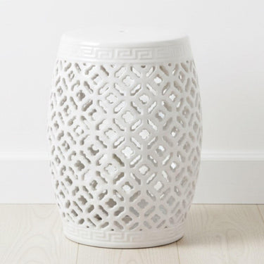 Minimalist white lattice ceramic stool styled as a bright decorative accent in a sunlit, airy room.