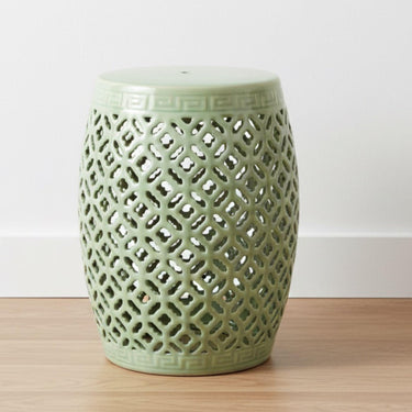 Sage green lattice ceramic stool styled as a sculptural focal point in a bright minimalist living room