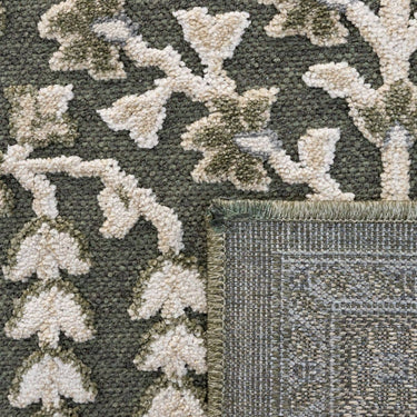 close-up of the traditional botanical floral pattern on the sage and olive green area rug