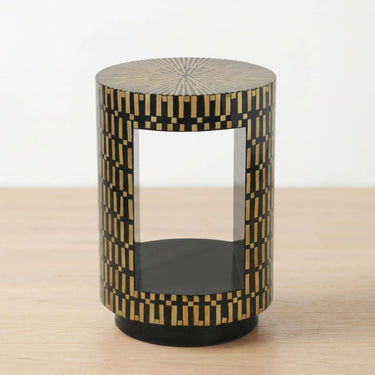 side table with a black and natural geometric inlay pattern, featuring a clear open space on the front and a black circular base.