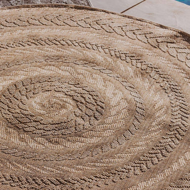 Close-up of a textured round rug with intricate patterns on a tiled floor.