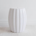 Minimalist white accent table styled in a clean modern living room setting.