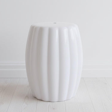 Minimalist white accent table styled in a clean modern living room setting.