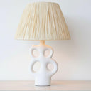 White ceramic table lamp with organic cut-out base