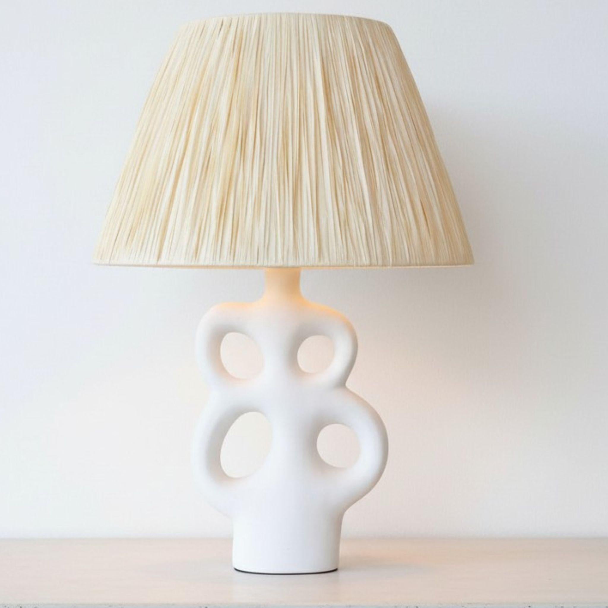 White ceramic table lamp with organic cut-out base