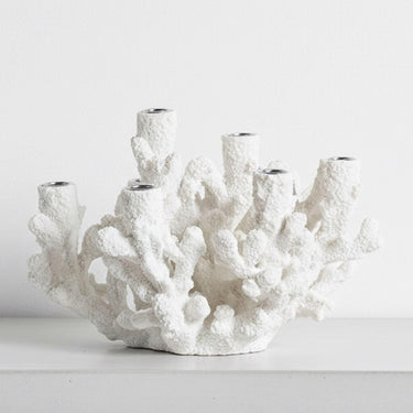Large white coral tapered candle holder styled on a table 