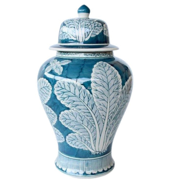 a blue and white vase with a leaf design on it