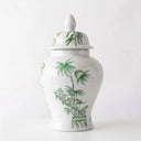 A white ceramic ginger jar with a lid, decorated with green hand-painted bamboo and pagoda motifs, set against a plain white background.