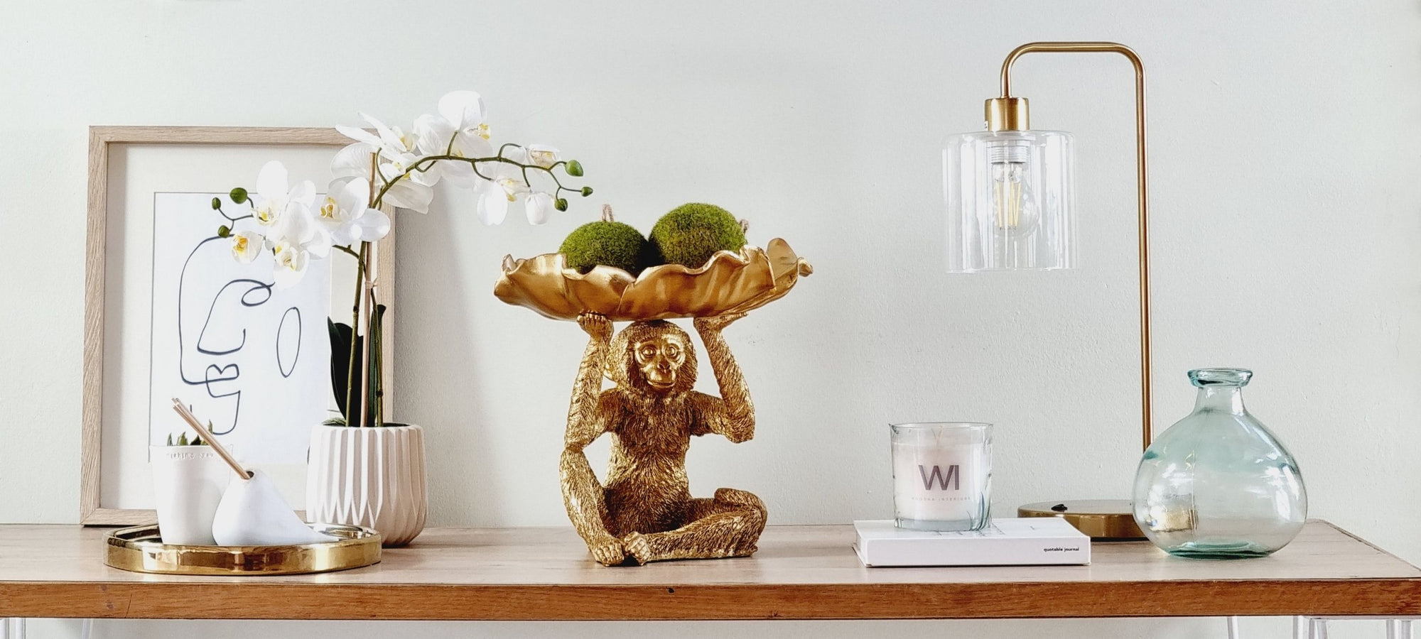 Styled table vignette with table lamp, decorative bowl and home decor accents from Woodka Interiors