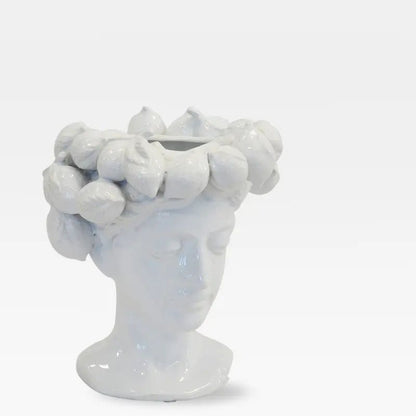 White ceramic face vase with a lemon crown